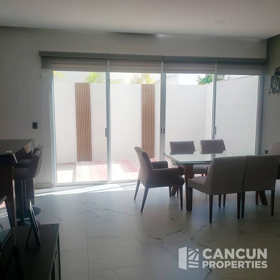 Living and dining room overlooking the back patio of a Río Residencial Cancun house